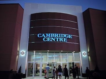 Exterior of a mall with crowd of people outside at dusk in Greenway-Chaplin, Cambridge, Ontario