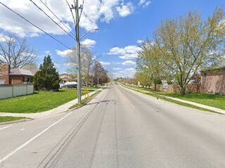 Empty asphalt road surrounded by power line, trees and houses in Silver Heights, Cambridge, Ontario